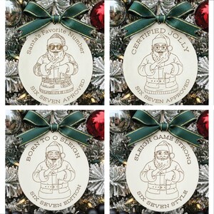 May include: Four wooden Christmas tree ornaments with green bows. Each circular ornament features a Santa Claus illustration and text. The phrases on the ornaments include "Santa's Favorite Number", "Certified Jolly", "Born to O Sleigh", and "Sleigh Game Strong".