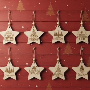 Może przedstawiać: Drewniane ozdoby świąteczne w kształcie gwiazd, z różnymi grawerowanymi wzorami i napisem "Merry Christmas". Wzory obejmują renifery, choinki i odciski łap. Każda ozdoba ma sznurek do zawieszenia.