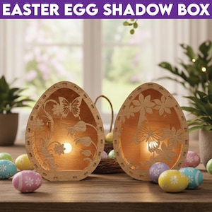 May include: Two wooden Easter egg shadow boxes with intricate butterfly and floral cutouts. The eggs are illuminated from within, creating a warm glow. The text "EASTER EGG SHADOW BOX" is at the top. Colorful Easter eggs are scattered around the base.
