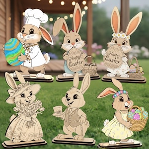 Könnte beinhalten: Osterhasen-Dekorationen aus Holz in verschiedenen Outfits, darunter ein Koch, eine Dame mit Hut und ein Herr mit Stock. Einige Hasen halten Ostereier oder Schilder mit der Aufschrift "Frohe Ostern".