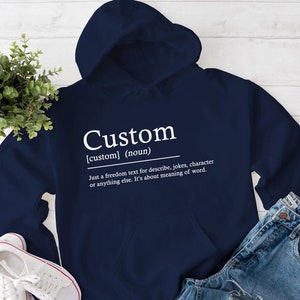 Può includere: Una felpa con cappuccio blu navy con la parola "Custom" e una definizione della parola in testo bianco.