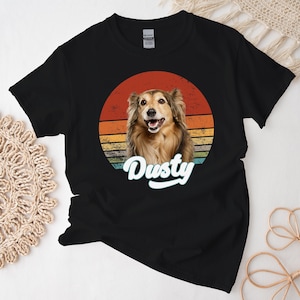 May include: Black t-shirt with a retro sunset design featuring a dog with the name "Dusty" in a blue font.