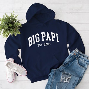 May include: Navy blue hooded sweatshirt with white text that reads "BIG PAPI EST. 2024".