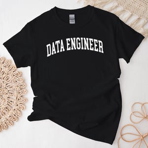 May include: Black t-shirt with white text that reads "DATA ENGINEER" in an arched font.