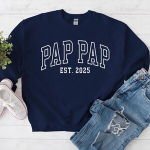 Peut inclure: Sweat-shirt bleu marine avec un texte blanc qui dit "Pap Pap Est. 2025".