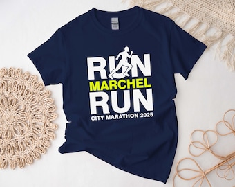 Może przedstawiać: Granatowa koszulka z napisem "RUN MARCHEL RUN" w kolorze białym i żółtym oraz sylwetką biegacza. Tekst "CITY MARATHON 2025" jest wydrukowany pod słowem "RUN".