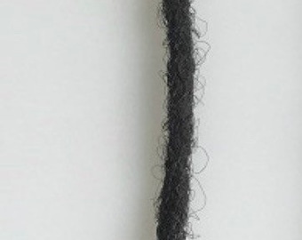 Może przedstawiać: Jeden czarny warkocz dreadlock.