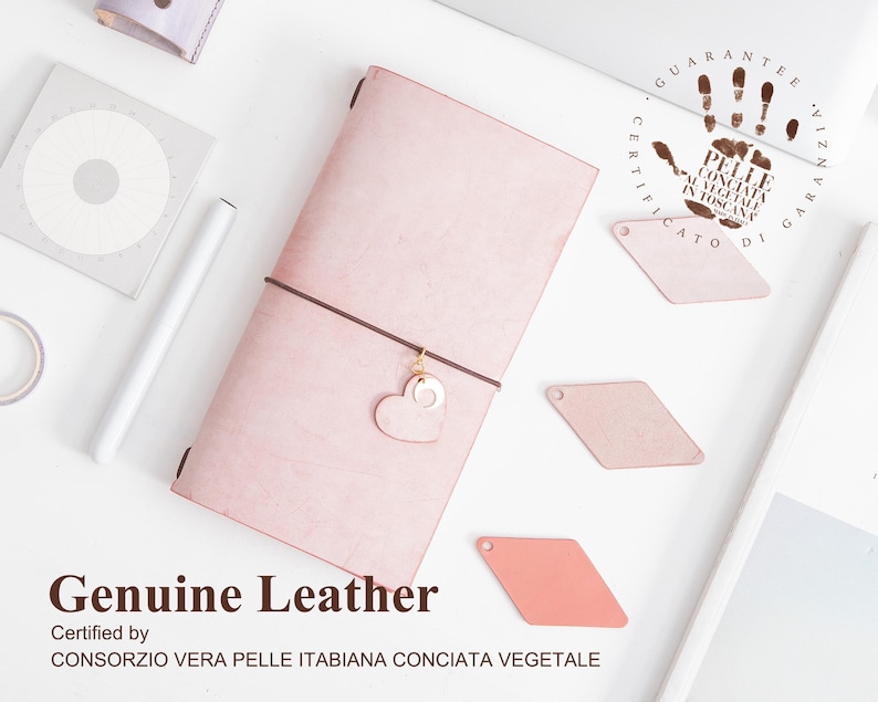 K&ouml;nnte beinhalten: Ein rosafarbenes Lederjournal mit einem herzf&ouml;rmigen Anh&auml;nger und dem Text "Genuine Leather Certified by CONSORZIO VERA PELLE ITABIANA CONCIATA VEGETALE" unten aufgedruckt.