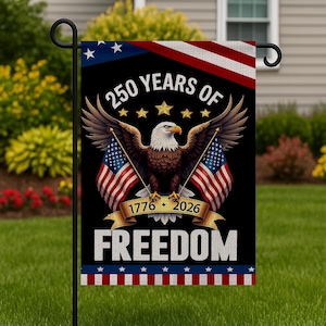 May include: A garden flag featuring a bald eagle with outstretched wings, holding two American flags. The flag reads "250 YEARS OF FREEDOM" with the years 1776-2026. The top has a blue field with white stars and a red and white striped border.