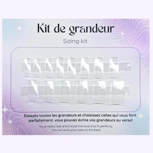 May include: A clear plastic sizing kit for nail tips. The kit includes multiple sizes of nail tips, labelled with numbers. The text on the card reads "Kit de grandeur Sizing kit Essayez toutes les grandeurs et choisissez celles qui vous font parfaitement, vous pouvez écrire vos grandeurs au verso! Try on every size and choose the ones that fit perfectly. You can write your sizes on the back"