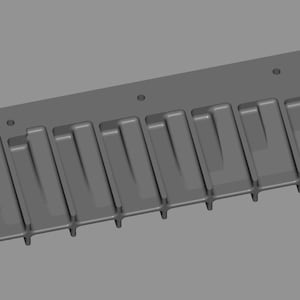 May include: A gray rectangular mold with a series of parallel, rectangular indentations. The mold has rounded corners and two circular holes at each end. The design suggests a tool for creating multiple, similar objects.