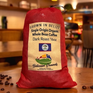 May include: A red bag filled with dark roast whole bean coffee. The bag has a label that says "Grown in Belize Single Origin Organic Whole Bean Coffee Dark Roast 16oz" and features the Belizean flag. The label also says "Belizean Grounds Belizean Flavor, Grounded in Tradition".
