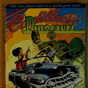 May include: A comic book cover featuring a black Cadillac with a woman in a red dress driving, a man in a blue shirt in the passenger seat, and three dinosaurs in the background. The title of the comic is "Cadillacs and Dinosaurs" by Mark Schultz.