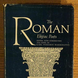 May include: A vintage book titled "The Roman Elegiac Poets" with a dark blue cover. The title and author's name are in white. The cover features a detailed illustration of a classical column.