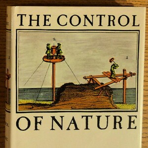 May include: A hardcover book titled "THE CONTROL OF NATURE" by John McPhee. The cover features a vintage illustration with figures operating machinery. The illustration is in shades of green, yellow, and blue, with the title in bold black letters.