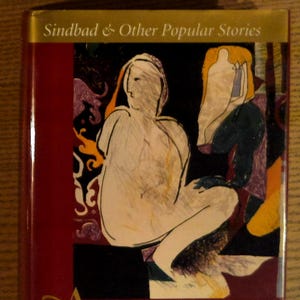 May include: A hardcover book titled "The Arabian Nights II" with a maroon cover. The cover features an illustration of two figures in a colorful, abstract style. The title is in gold lettering, and the book is translated by Husain Haddawy.