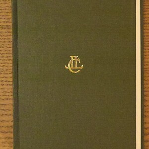 May include: A hardcover book with a dark green cover. A gold emblem is centered on the front. The book's pages are white, and the spine is a darker shade of green. The book is closed and appears to be in good condition.
