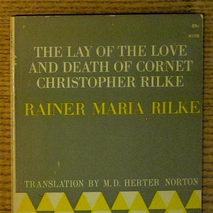 May include: Vintage paperback book cover titled "The Lay of the Love and Death of Cornet Christopher Rilke" by Rainer Maria Rilke. The cover is a muted green with yellow text and a geometric pattern in yellow, gray, and white.