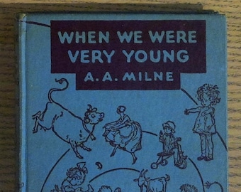 May include: A blue book cover with the title "When We Were Very Young" by A.A. Milne. The cover features illustrations of children and animals playing in a whimsical setting.