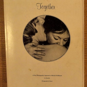 May include: A book cover with the title "Together" in elegant script. A circular image shows two people embracing. The cover also includes text: "A New Photographic Approach to Marital Fulfillment" by Danielle, Photographs by Stuart.