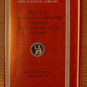 May include: A red hardcover book from the Loeb Classical Library featuring the title Seneca, Oedipus, Agamemnon, Thyestes, Hercules on Oeta, Octavia, with text edited and translated by John G. Fitch and a circular logo depicting a seated figure.