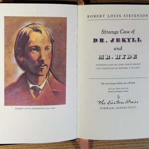 May include: Open book with the title "Strange Case of Dr. Jekyll and Mr. Hyde" by Robert Louis Stevenson. The left page features a portrait of the author. The book is a collector's edition from The Easton Press.