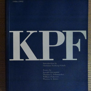 May include: A blue book cover with the title "KPF" in white letters. The book is about Kohn Pedersen Fox Architecture and Urbanism from 1986-1992. The book was edited by Warren A. James and includes essays by Joseph Giovannini, Thomas L. Schumacher, William Pedersen, and Warren A. James.