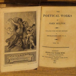 May include: An open book featuring the title "The Poetical Works of John Milton" and an illustration of a classical scene. The book is bound in a dark material, with text and illustrations in black ink on aged paper. The volume is marked "Vol. III."