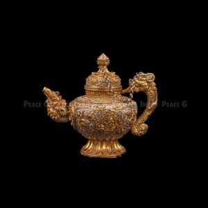 May include: Ornate gold and silver teapot with intricate floral and dragon detailing. The teapot features a dragon-shaped handle and spout, with a decorative lid and base. The design is highly detailed and the teapot is set against a black background.
