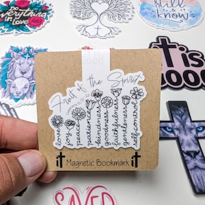 May include: A collection of stickers and a magnetic bookmark. The bookmark is brown with the words "Fruit of the Spirit" and a list of virtues. Other stickers include floral designs, inspirational quotes, and religious imagery.