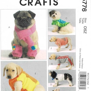 May include: A sewing pattern for dog clothes, featuring a variety of dog breeds wearing different outfits. The pattern includes a scarf, a hooded sweater, a striped sweater, a vest, and a polka dot sweater.