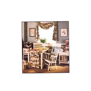 May include: A white dining table with a floral tablecloth and a white chair. The table is set with a floral centerpiece and a white pitcher. The room is decorated with floral curtains and artwork.