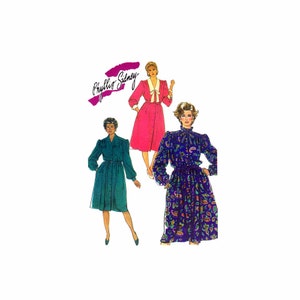 May include: Three women's dress patterns featuring a long-sleeved dress with a bow at the neck. The dresses are in pink, teal, and a purple and green paisley print. The pattern is by Phyllis Sidney.