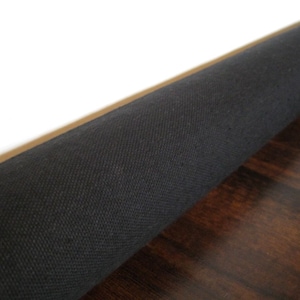 May include: A close-up of a black fabric roll, partially unrolled, revealing a dark brown wood surface underneath.
