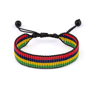May include: A beaded bracelet with the colors of the Mauritian flag. The bracelet is made of small, colorful beads strung on a black cord. The beads are arranged in stripes of red, blue, yellow, and green.