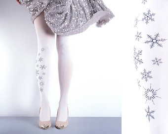 May include: White tights with a snowflake pattern. The tights are worn by a person wearing a silver sequined skirt.