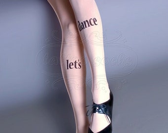 May include: A pair of sheer nude tights with the words "let's dance" printed on them. The tights are worn by a person wearing black shoes.