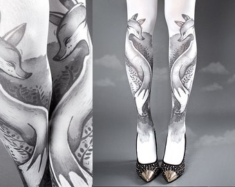 May include: White tights featuring a black and white fox design. The foxes are facing each other and appear to be cuddling. The tights are modelled on a person wearing a black skirt.