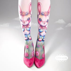 May include: Pink tights with a bunny illustration and pink heels. The bunny design features a floral crown and a colorful outfit. The heels are a vibrant pink color, and the tights have a floral design at the bottom.
