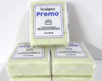 May include: Several packages of Sculpey Premo oven-bake clay. Each package is wrapped in clear plastic and features a white label with blue text. The label includes the brand name, product name, and weight: 2 oz (57 g).