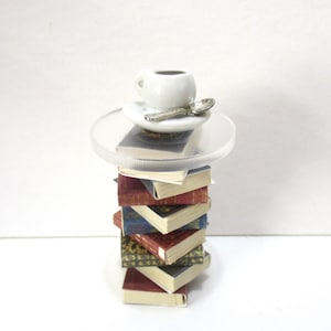 Miniature stack of Old books as a side table with a miniature coffee cup
