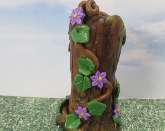 Miniature tree stump with vines of purple flowers   Fairy garden or terrariums