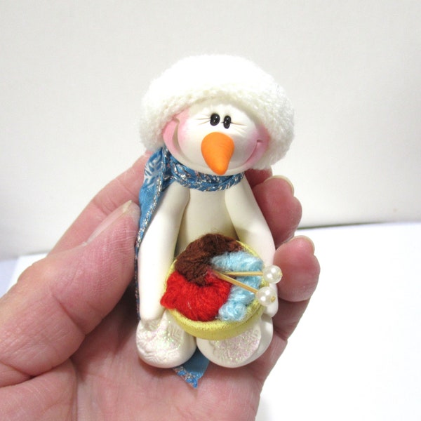 Snowman ornament Warming up with Knitting or crocheting