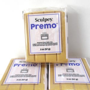 May include: Several packages of Sculpey Premo oven-bake clay. Each package is gold-colored and wrapped in clear plastic. The label features the brand name, product name, and a graphic of an oven. Each package contains 2 oz (57 g) of clay.