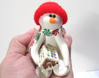 Snowman ornament and a miniature gingerbread house