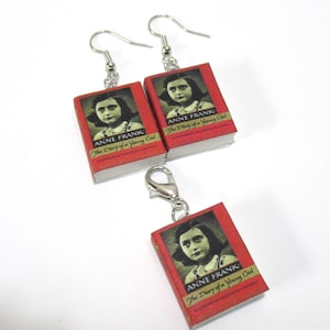 May include: A set of silver earrings and a charm featuring miniature book replicas of "Anne Frank: The Diary of a Young Girl".
