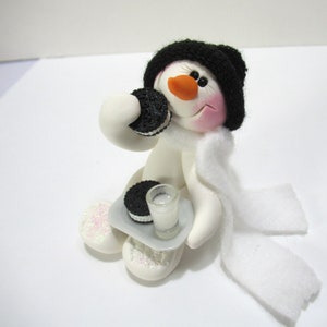 Snowman ornament and favorite cookies plate of oreo sandwich cookies