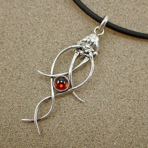 May include: Silver pendant necklace with a red gemstone and a swirling, abstract design.