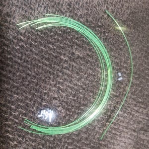 May include: A bundle of green plastic trim pieces for a car. The trim pieces are flexible and can be used to cover gaps or edges.