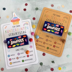 Könnte beinhalten: Zwei rechteckige Geburtstagskarten mit buntem Text und Grafiken, jeweils mit einer kleinen Schachtel Smarties Mini befestigt. Die Karten enthalten den deutschen Text FÜR EINEN KUNTERBUNTEN GEBURTSTAG und GANZ VIEL, mit Listen positiver Eigenschaften.